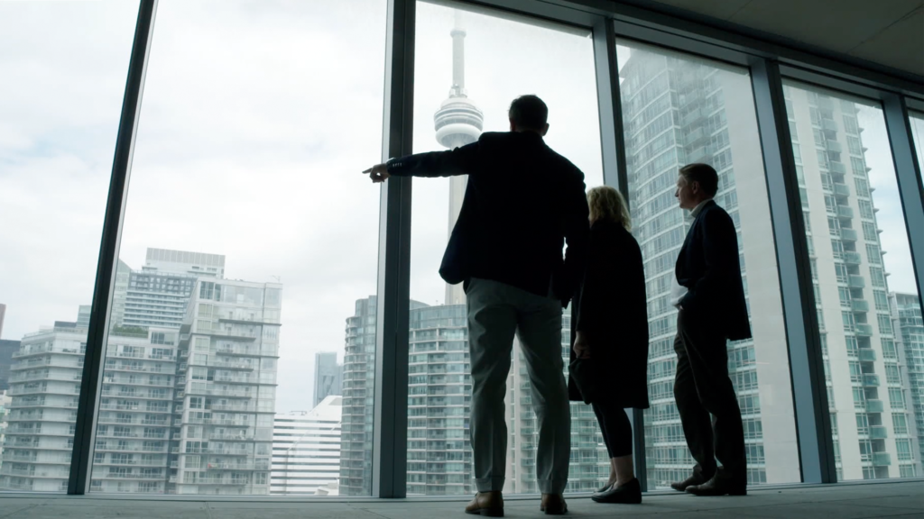 Three business people in an office overlooking Toronto