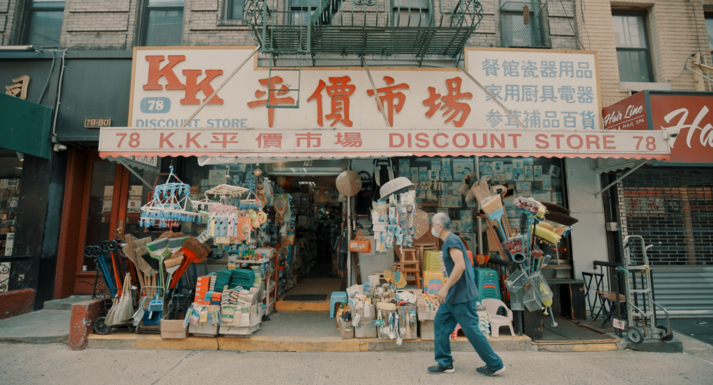 A discount storefront in Chinatown with a man walking by