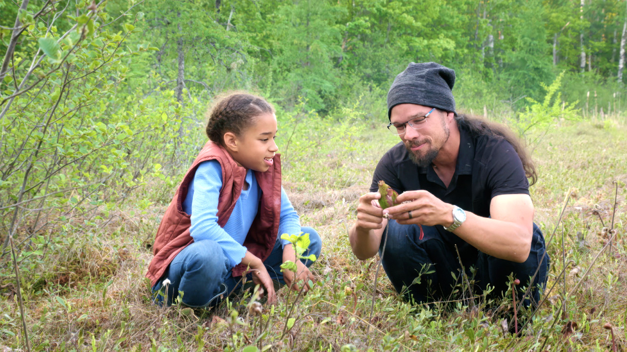 Taviss and Joe Pitawanakwat examining  plants